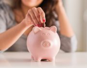 Woman saves money for Thailand Plastic Surgery by putting coins into a pink piggy bank